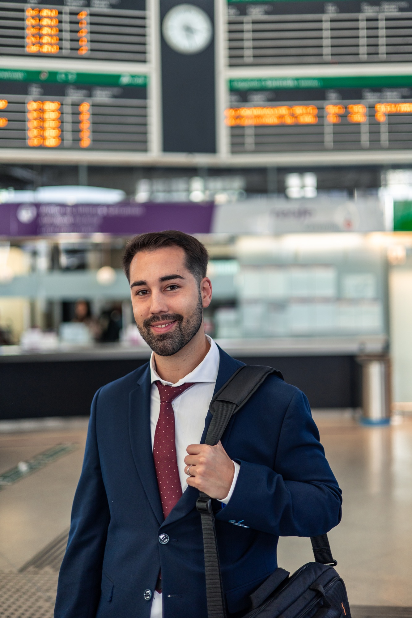 vertical Smiling businessman poses in train station on his way to work using public transport